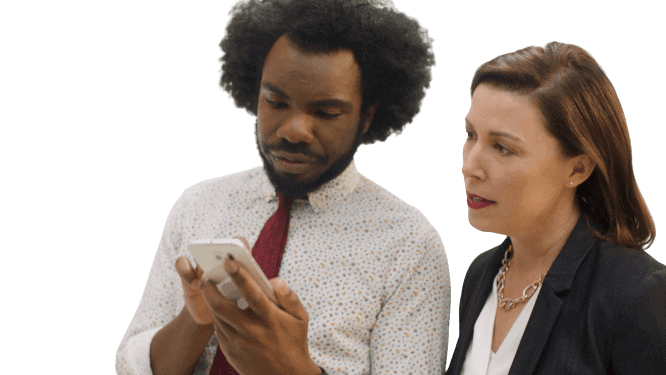 A manager and employee looking at a phone together.