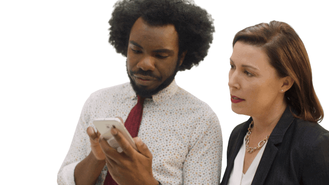 A manager and employee looking at a phone together.